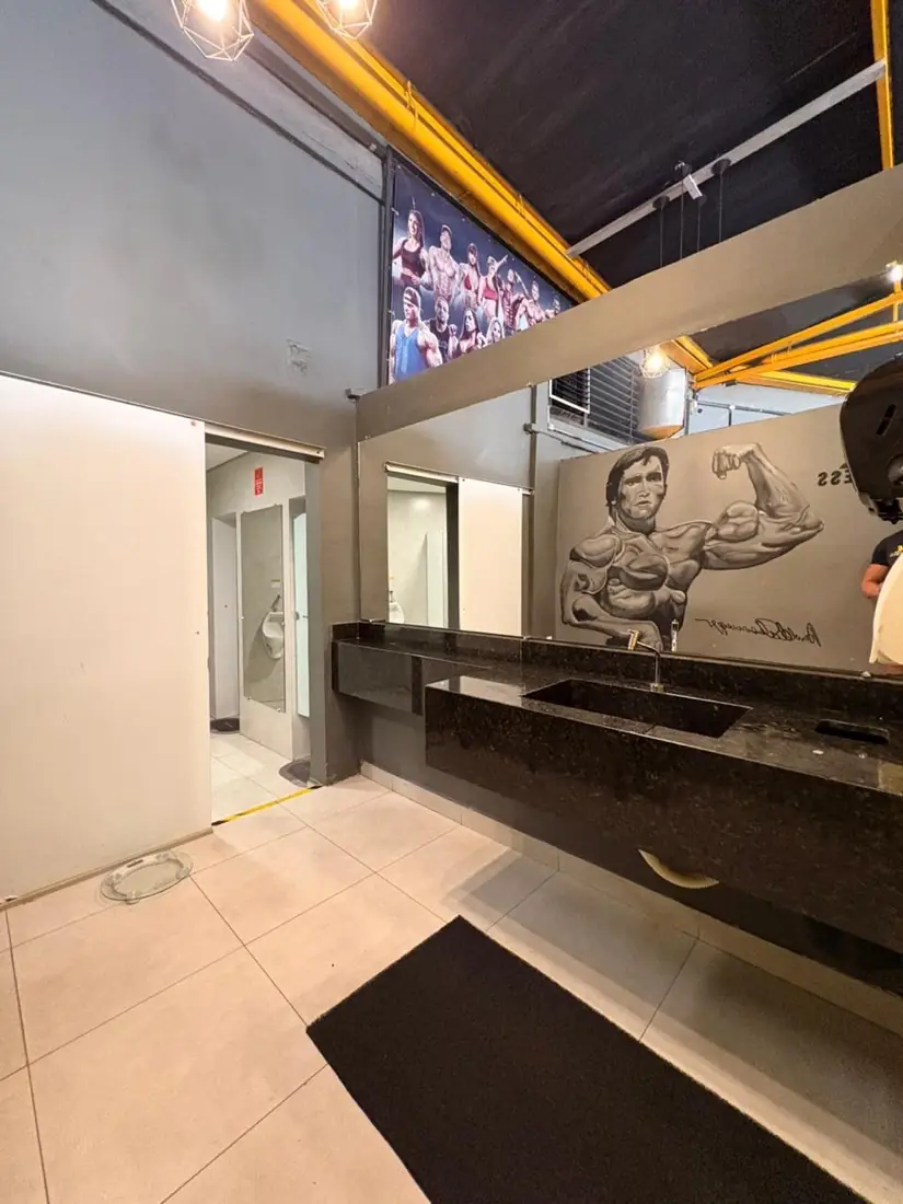 Área de convivência com mural artístico na academia VL Fitness em Contagem
